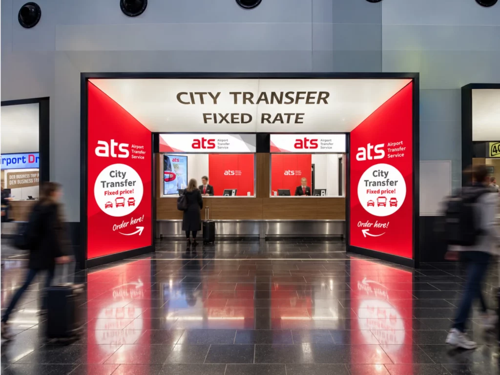 ATS Airport Transfer Service Schalter am Flughafen Wien mit großflächiger Markeninszenierung und Werbetechnik
