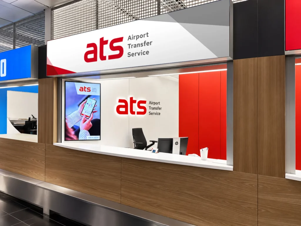 ATS Verkaufsschalter am Flughafen Wien mit Corporate Design, Leuchtreklame und digitalem Werbescreen